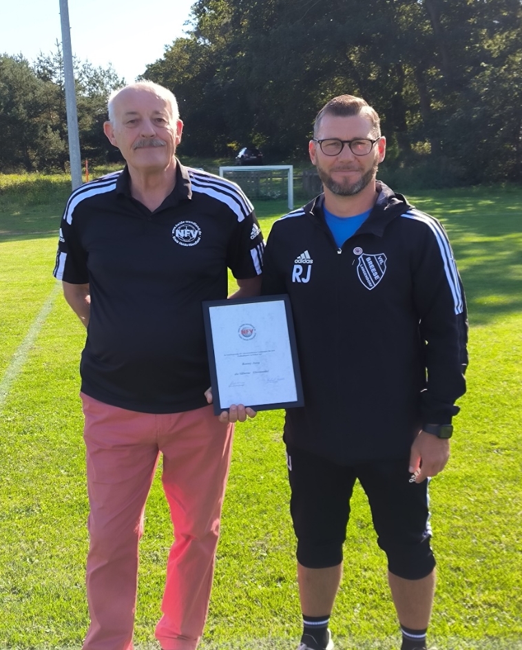 Ronny Jung (r.) vom VfL Breese-Langendorf erhält vom Kreisehrenamtsbeaftragten Gisbert Stevens die Silberne Ehrennadel des Kreises