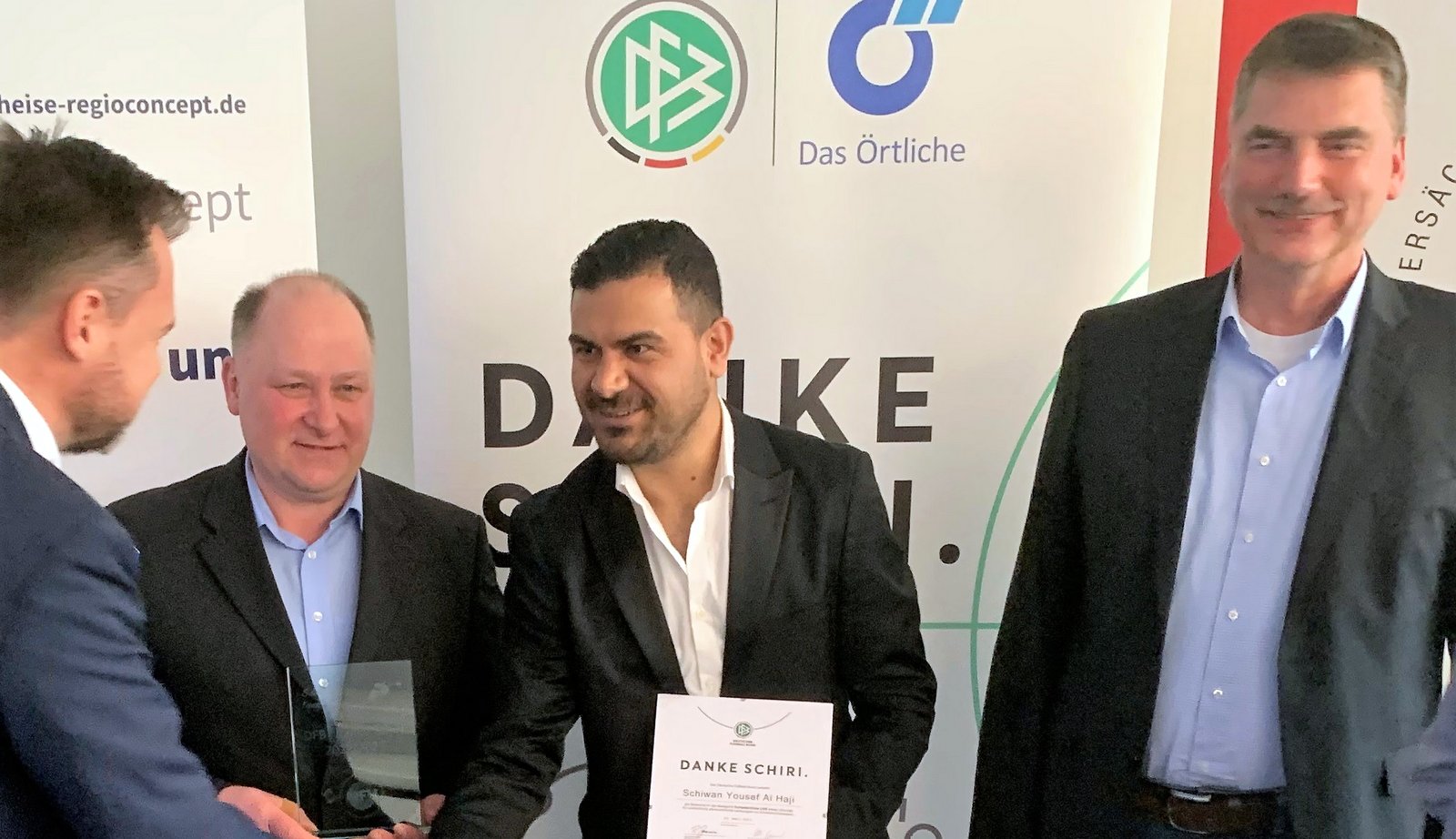 Schiwan Yousef Al Haji nimmt dankend die Urkunde entgegen. Links neben ihn  BSO Jürgen Bockelmann, rechts: KSO Volker Leddin