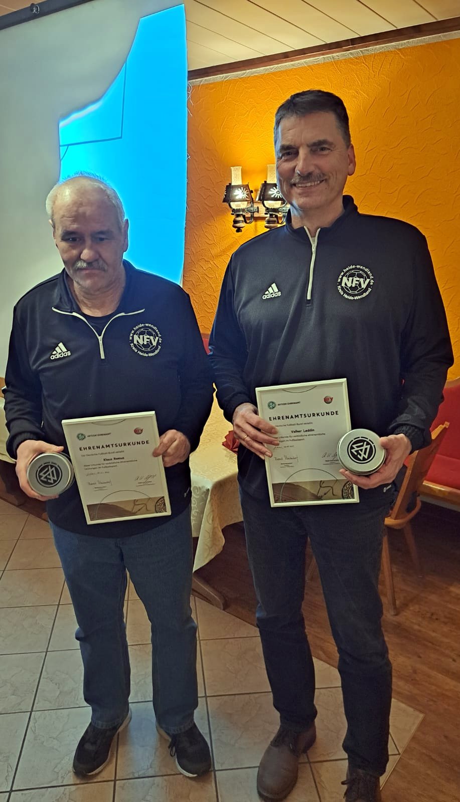 Klaus Remus (l.) und Volker Leddin mit Uhr und Urkunde